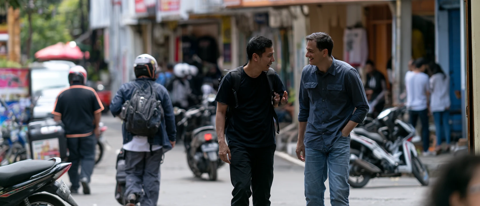 A Singapore enterprise leader walking through an Indonesian commercial district with a local market specialist